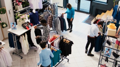 Top view of diverse customers checking stylish clothes, shopping for fashionable merchandise and accessories in modern boutique